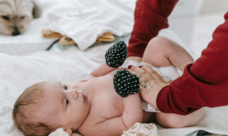 Mother changing diaper for newborn baby